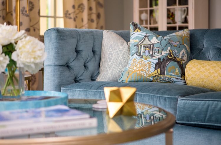 Neutral tan sofa with blue-grey and celery green throw pillows