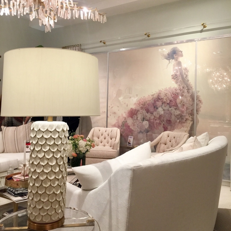 Crypton fabric for Duralee at High Point Furniture Market blush pink and white showroom with white shell lamp, pink tufted chairs, white sofa, and art with dress made of pink flowers