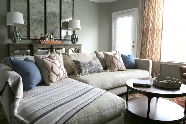 masculine room design by The Decorologist with Pottery Barn sectional chaise sofa, round rustic wood coffee table