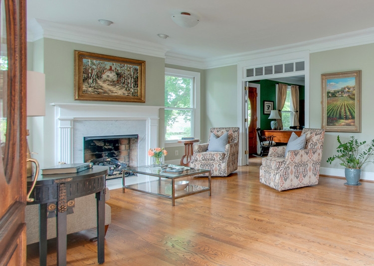 staged historic living room white white millwork fireplace and light gray green walls
