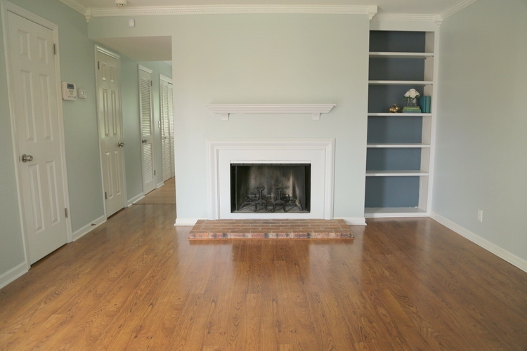 light gray blue walls in rental property with fireplace and built in bookcases