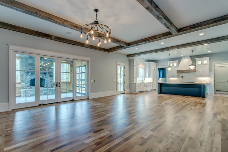 open floor plan home with dark wood beams on ceiling