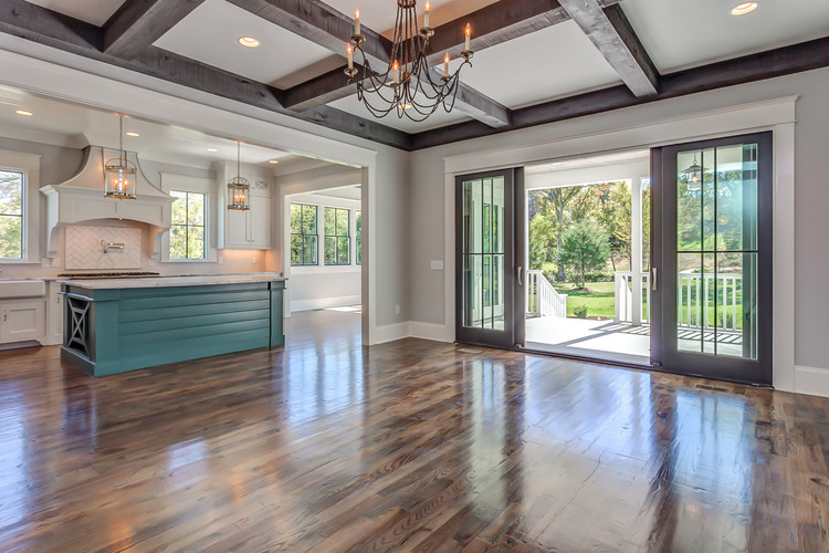 open floor plan kitchen and living room with green island and dark stain cross beam ceiling, color design by The Decorologist