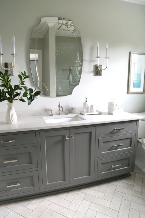 gray cabinet and herringbone pattern tile bathroom makeover by The Decorologist