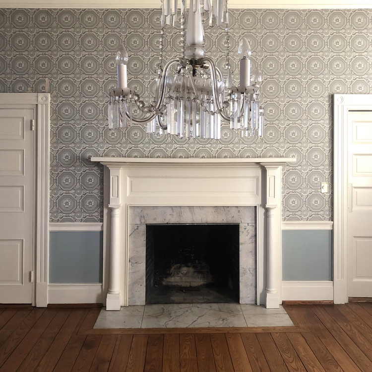 historic dining room fireplace mantel with crystal chandelier