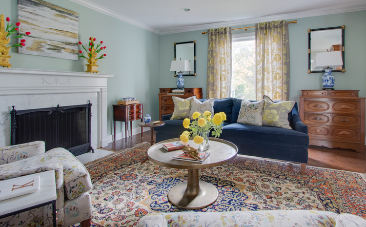 blue sofa in living room with antique rug and green walls