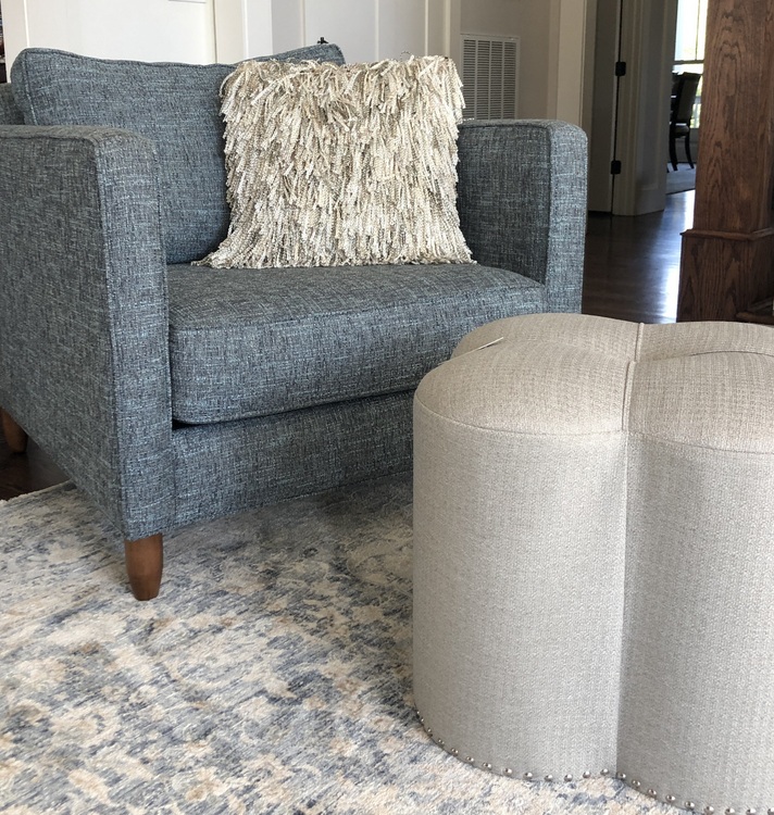 blue upholstered chair and clover shaped ottoman